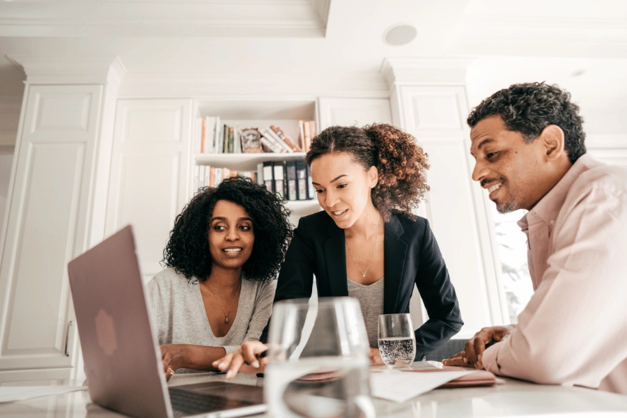 real estate agent working with clients on a laptop